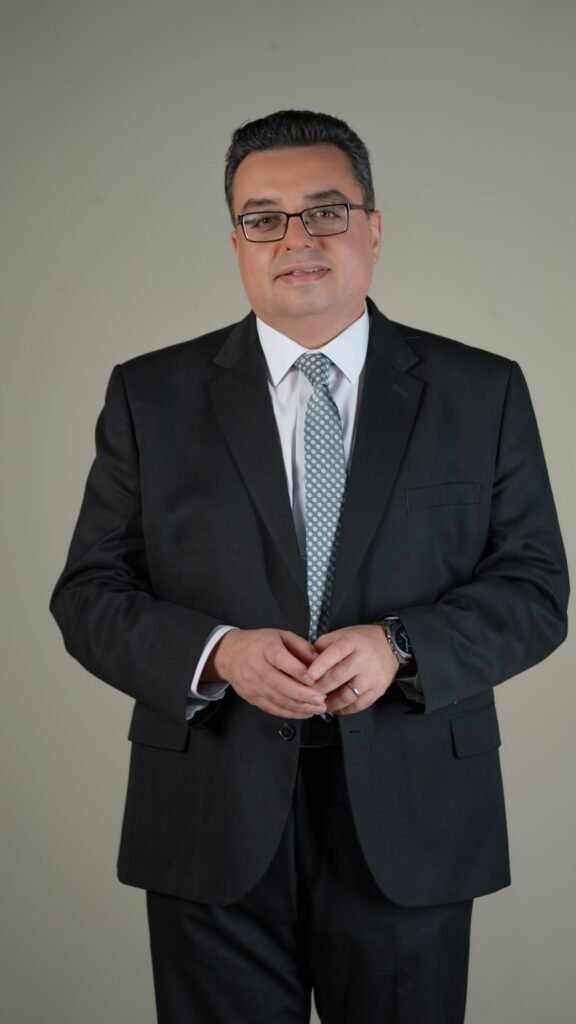 أ.د. سامح حسن في صورة شخصية بالبدلة وربطة العنق الرمادية.